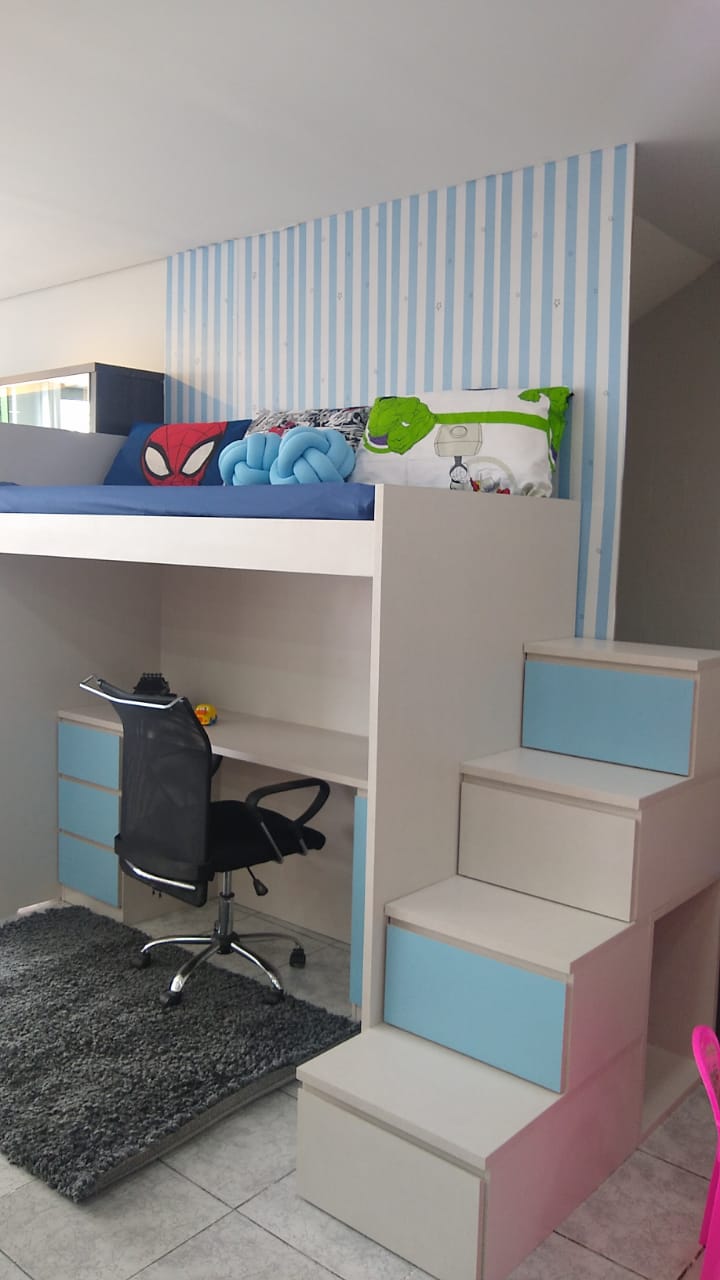 Um quarto com beliche, mesa, cadeira e escada.