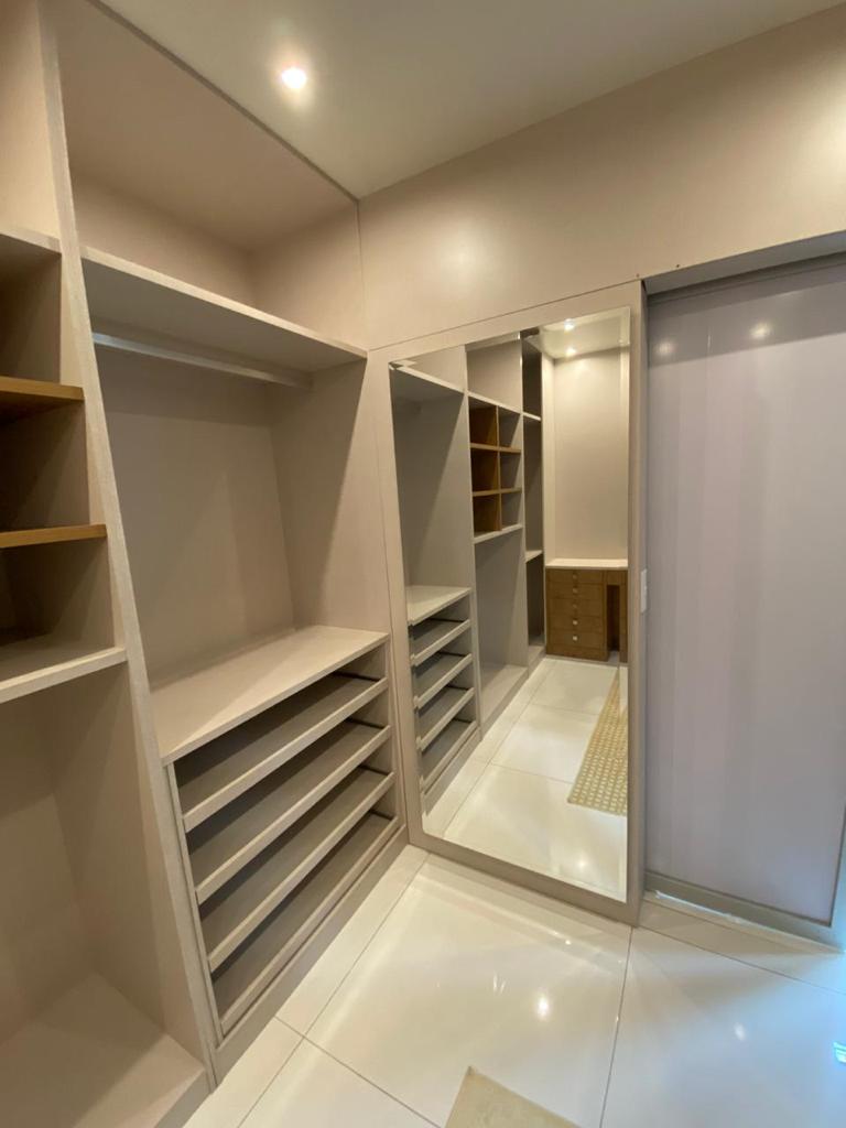 Um closet com muitas prateleiras e um espelho grande.