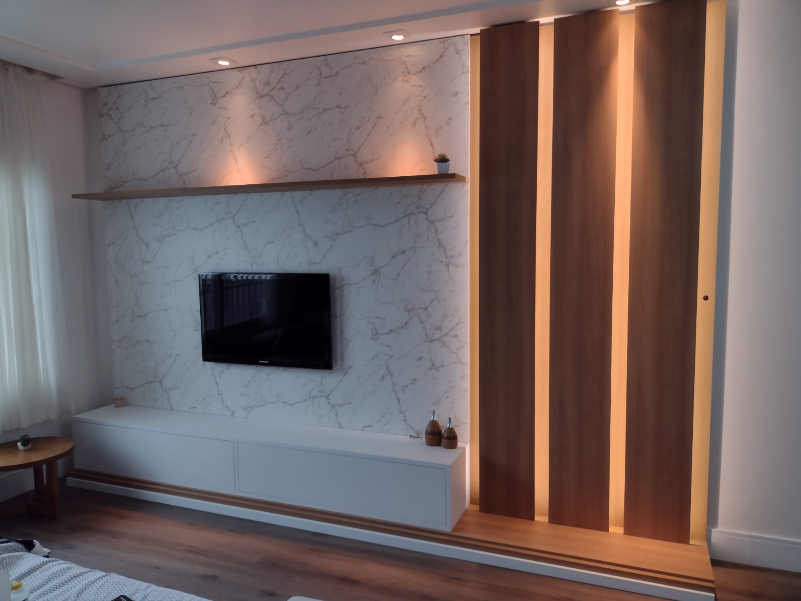 Uma sala de estar com TV de tela plana na parede.