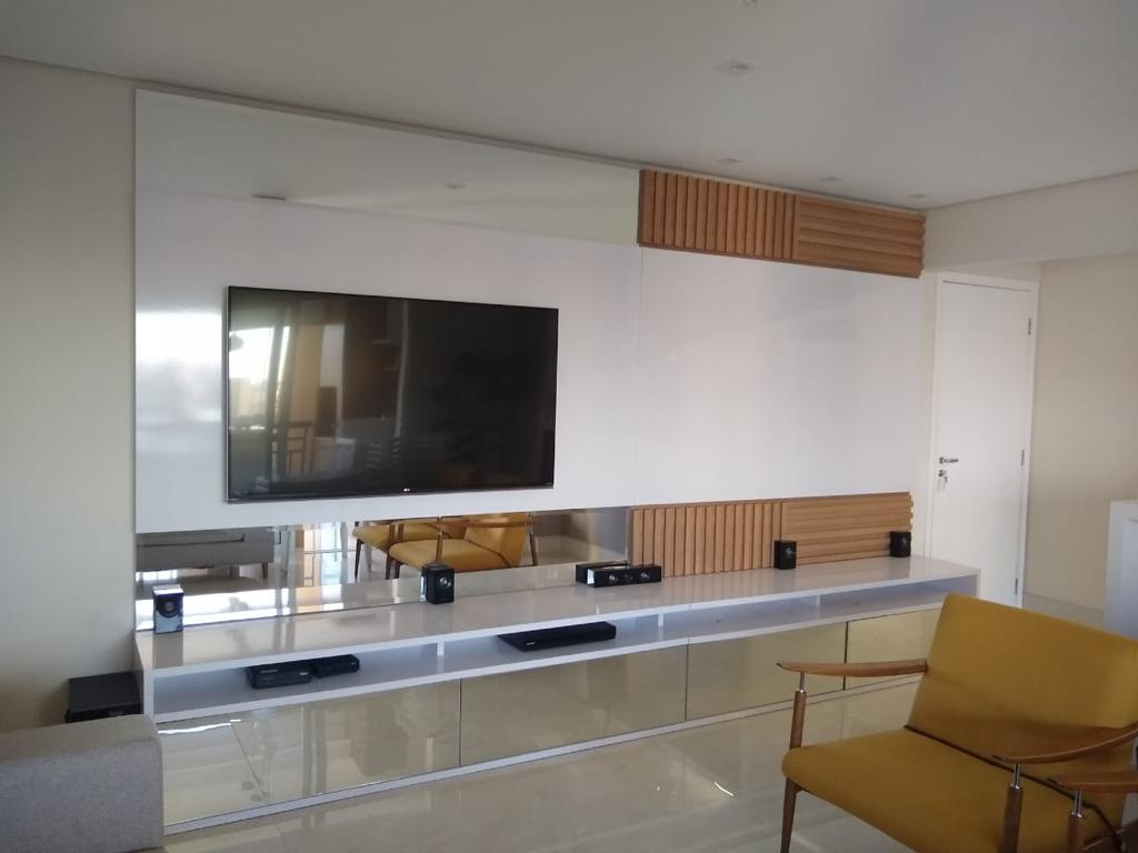 Uma sala de estar com uma TV de tela plana grande na parede