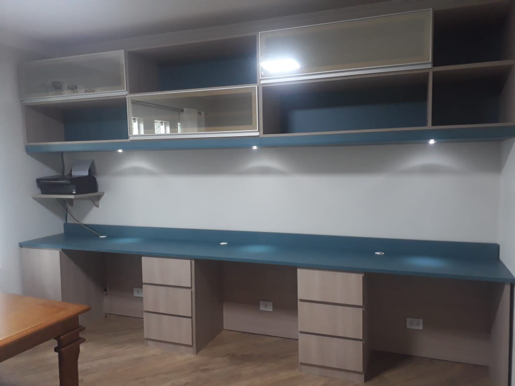 Uma longa mesa com gavetas embaixo em uma sala