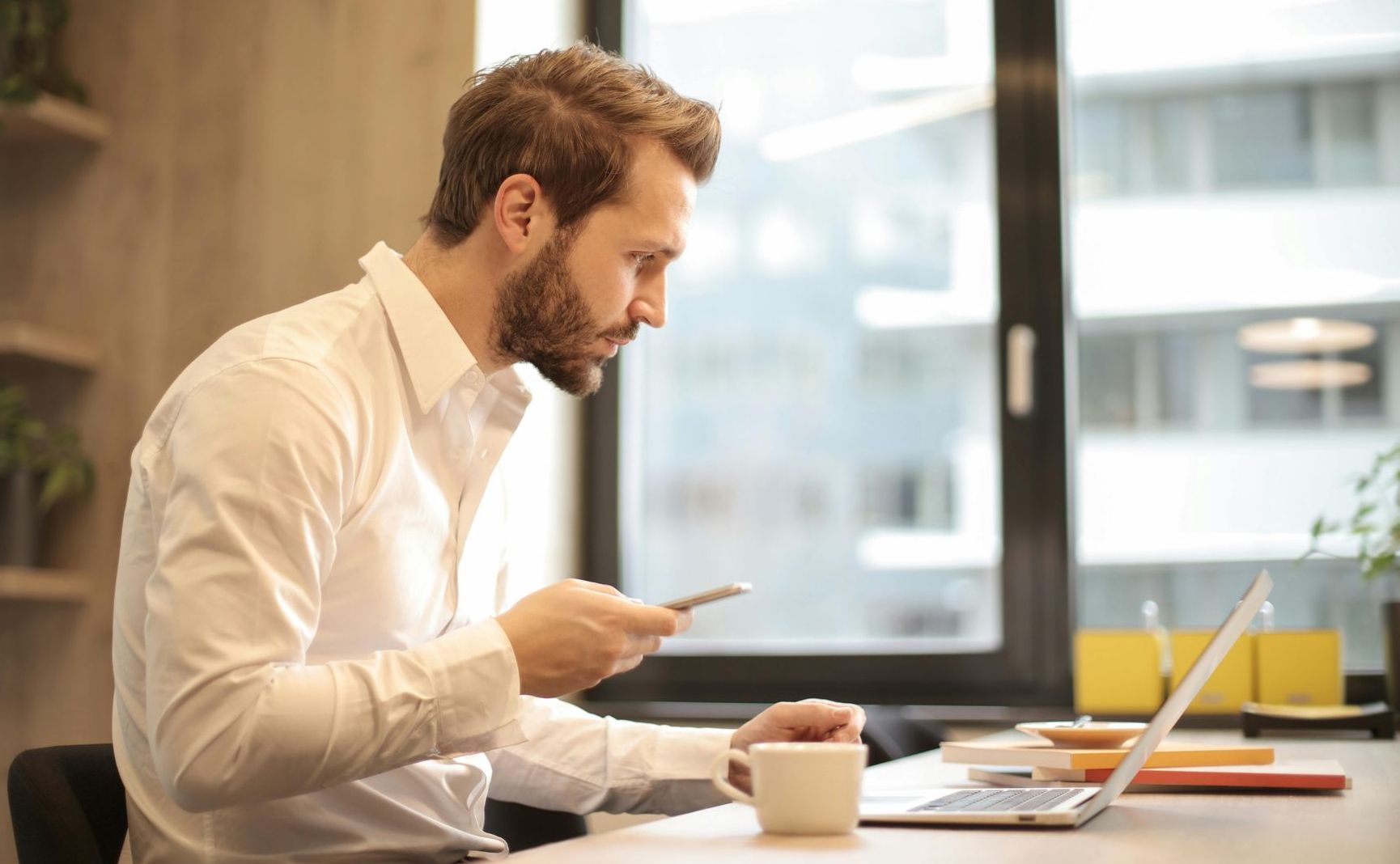 A man in an office looking at a laptop
