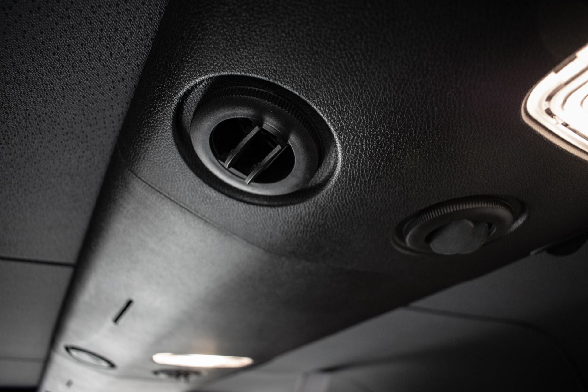 A black and white photo of the ceiling of a car.