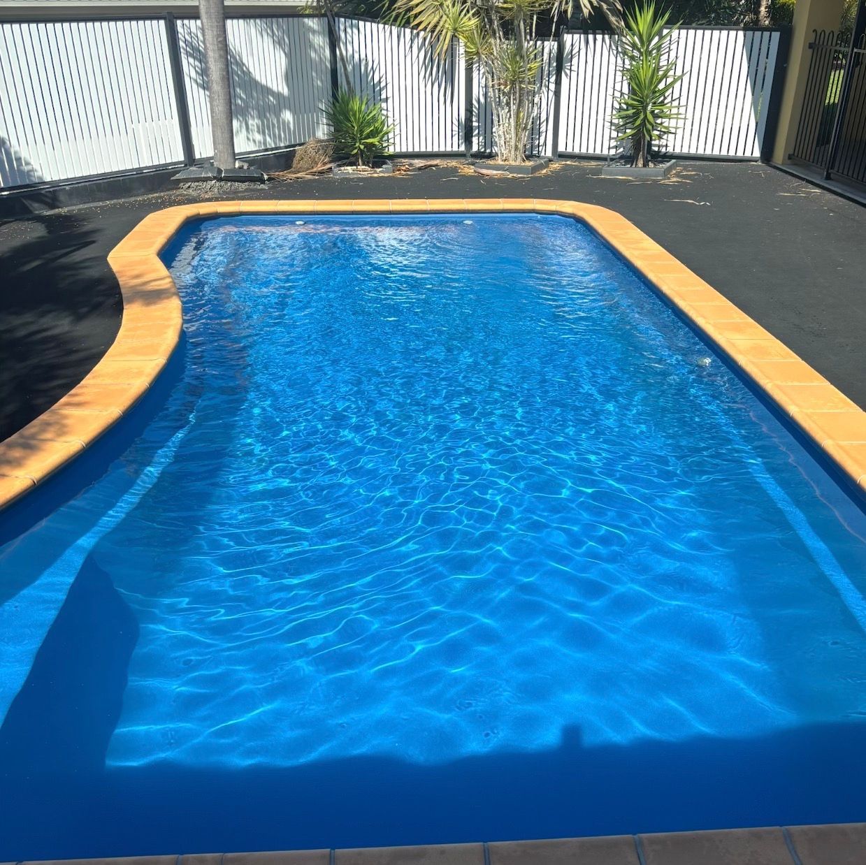 A Large White House With a Swimming Pool in Front of It — Pool Maintenance in Pacific Heights, QLD