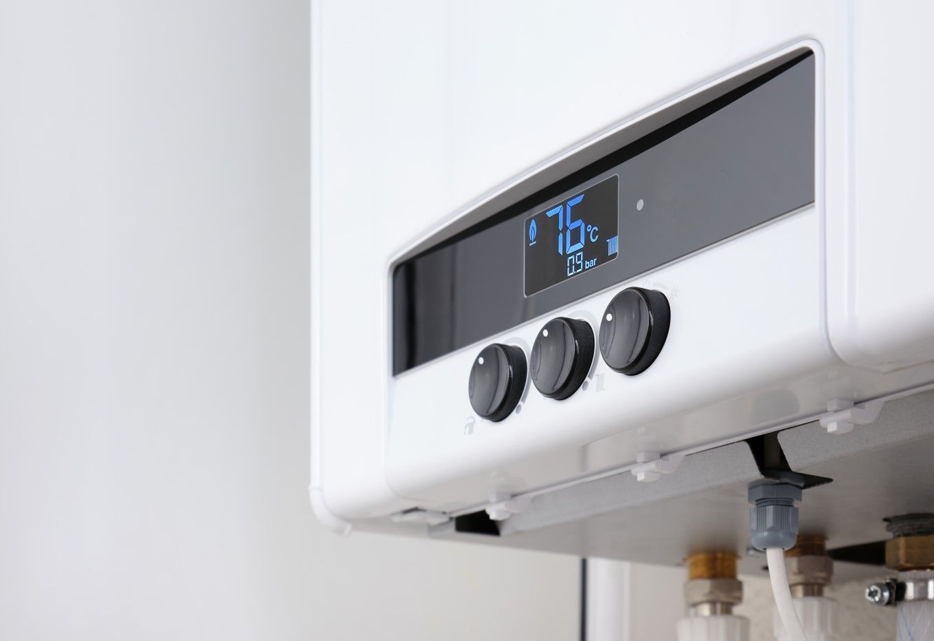 White wall-mounted water heater with a digital display showing 76°F and three control knobs.