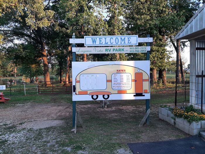 Sign for Laguna Vista RV Park; shows a cartoon trailer with a welcome message.