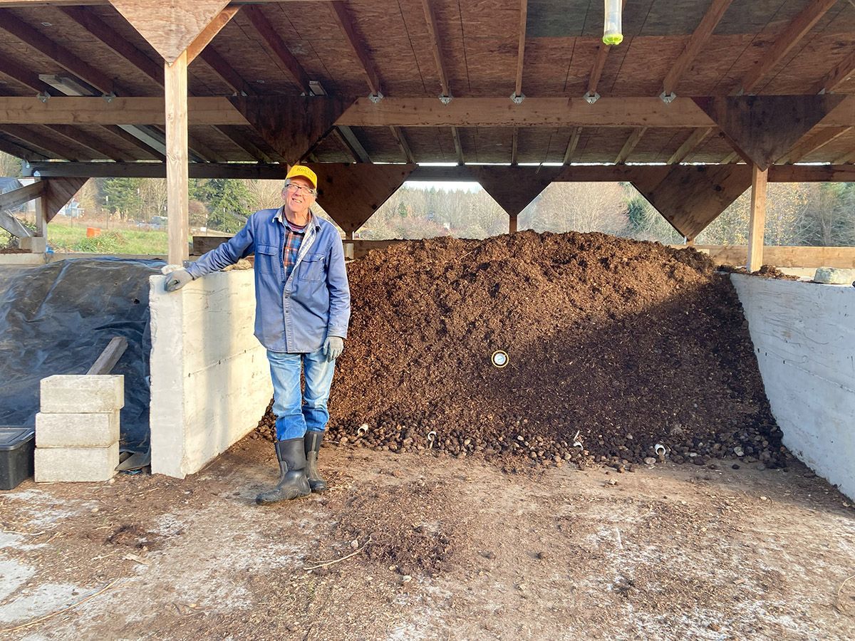 Farmer Bob Gilbey standing in front of loaded compost bunker