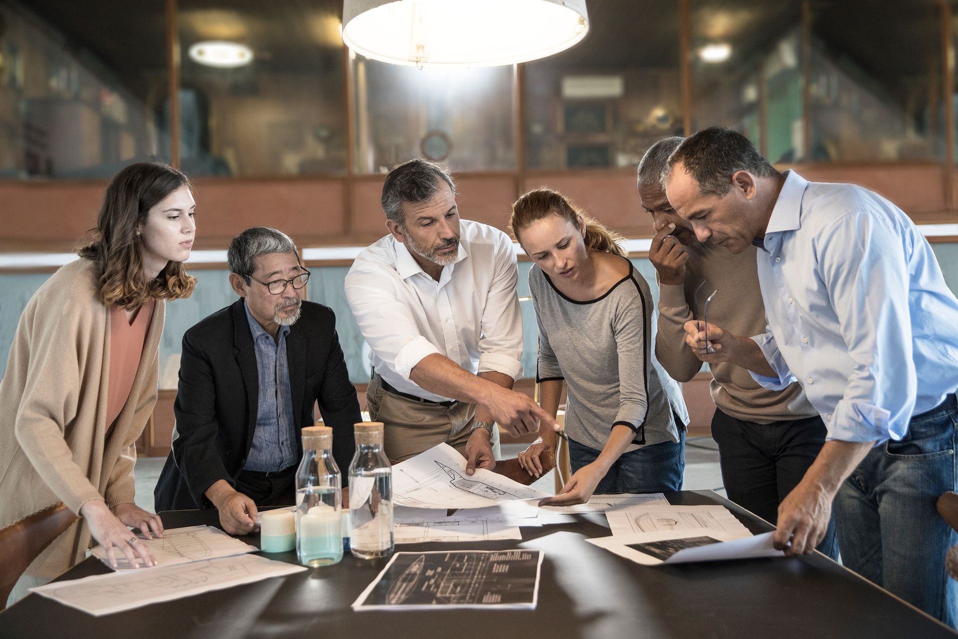 Un uomo è seduto alla scrivania davanti a un computer portatile.