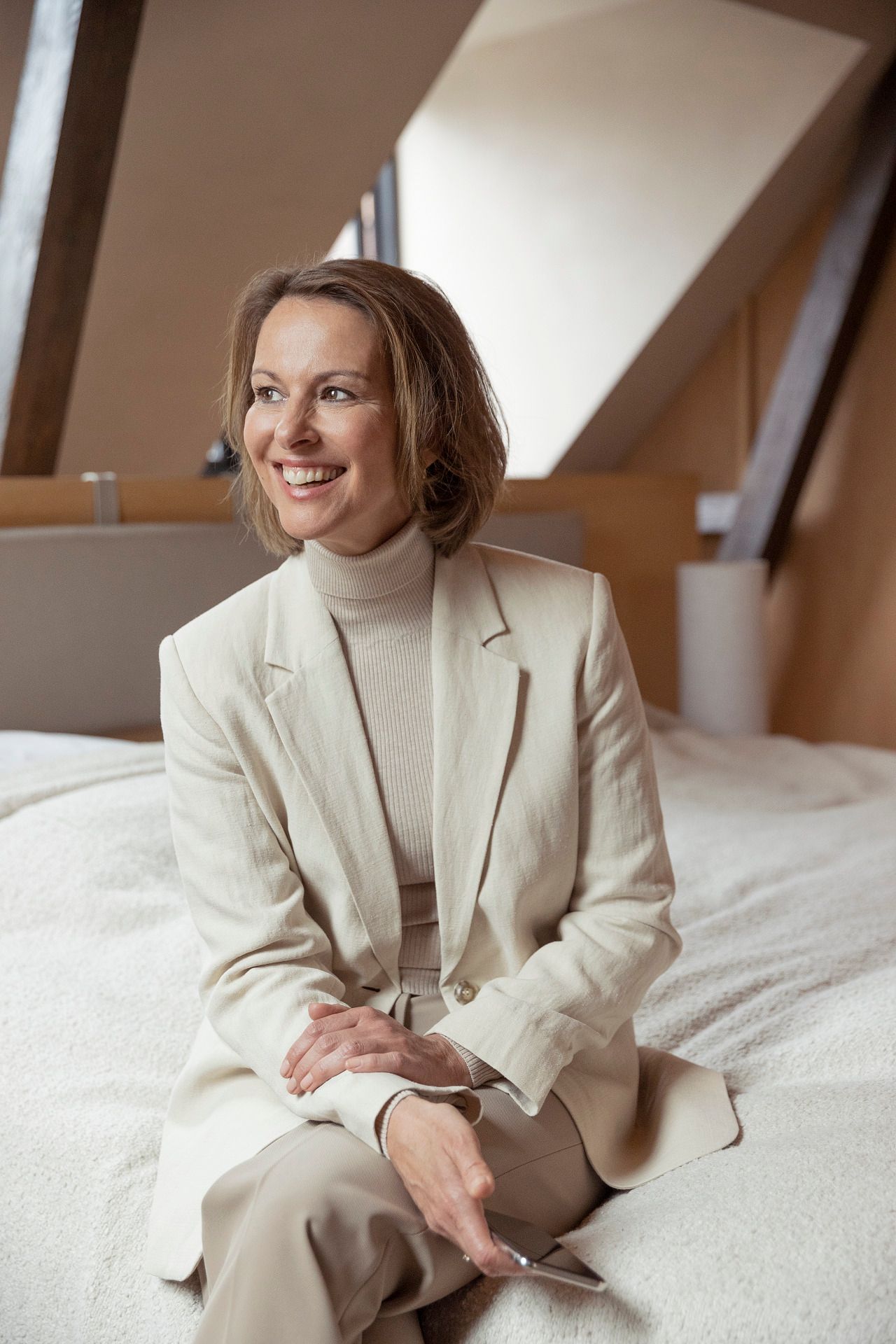 donna vestita di bianco seduta su letto