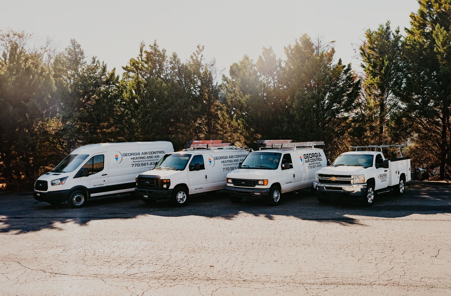 A row of white trucks parked in a parking lot