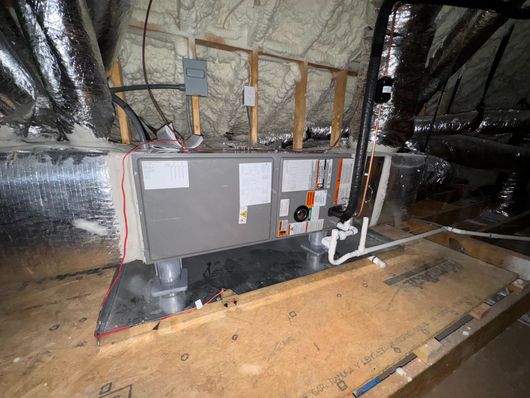 A lynx air conditioner is sitting in a room next to a wall.