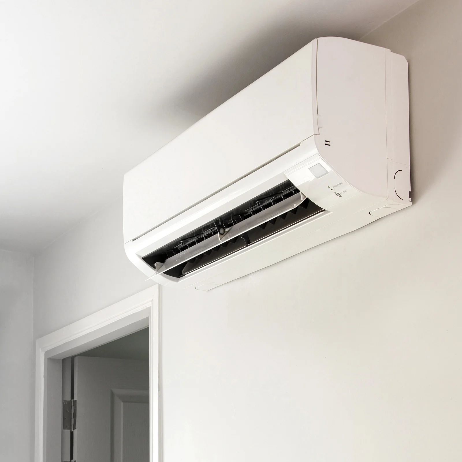 White air conditioning unit mounted on a light gray wall.