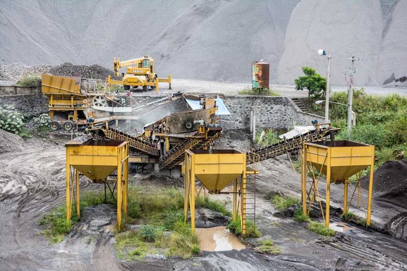 Una gran máquina amarilla está sentada en medio de un campo de tierra.