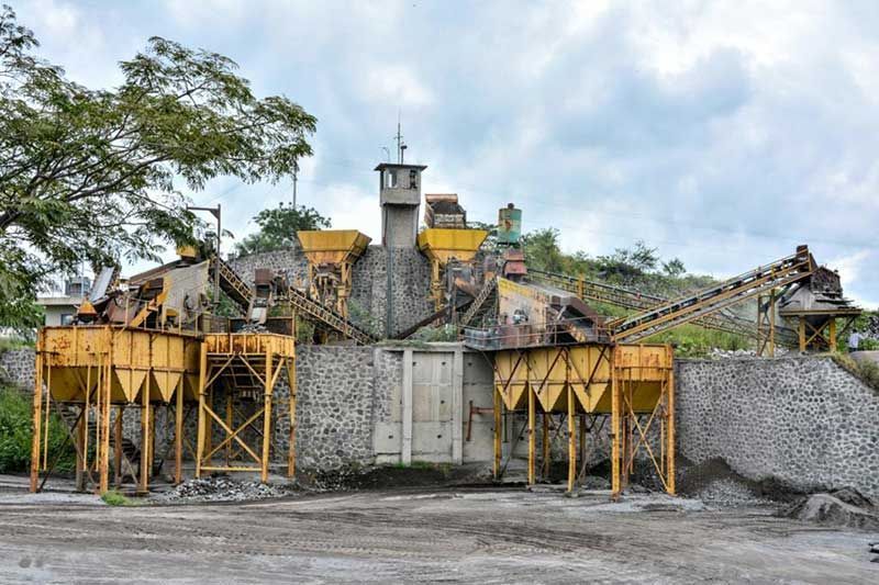 Un edificio grande con mucha maquinaria enfrente.