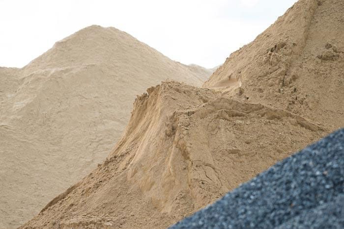 Un montón de arena y grava al lado de una montaña.