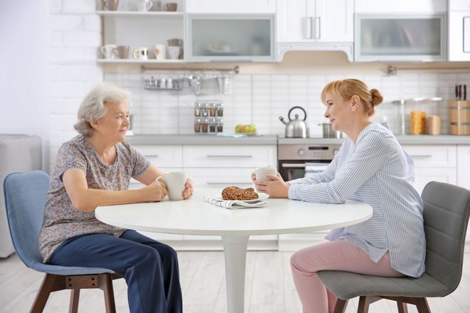 Two people talking at kitchen table