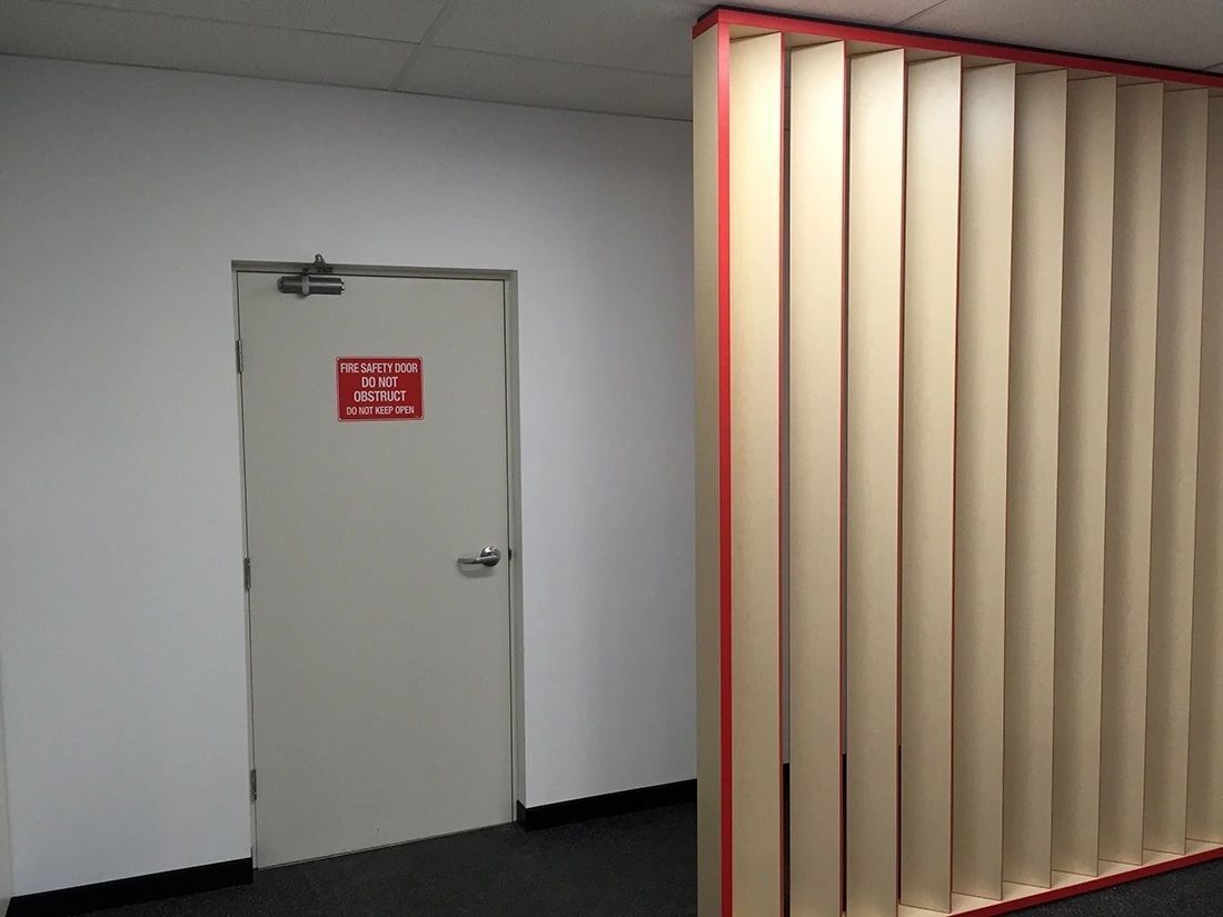 A hallway with a door and a divider in the middle.