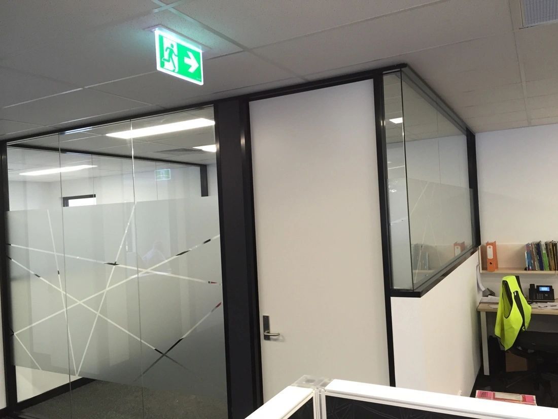 An office with a green exit sign on the ceiling