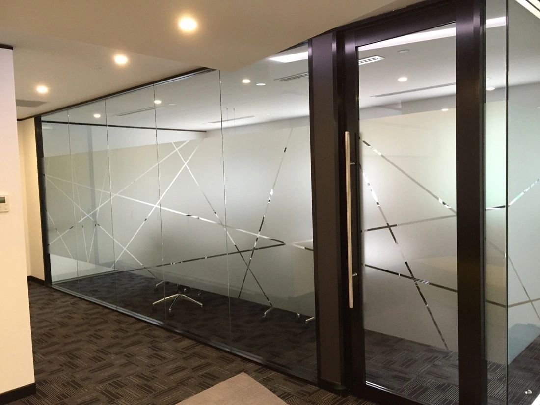 A hallway with a glass wall and a door.