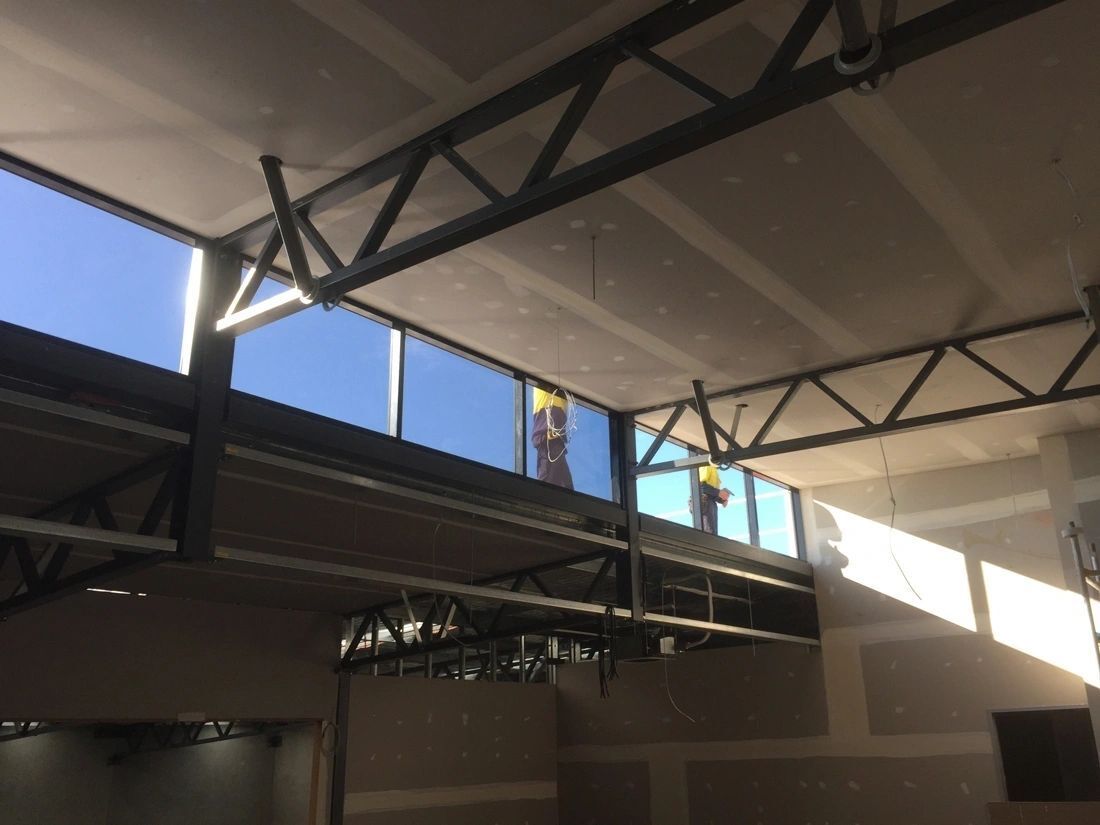 A man is working on the ceiling of a building