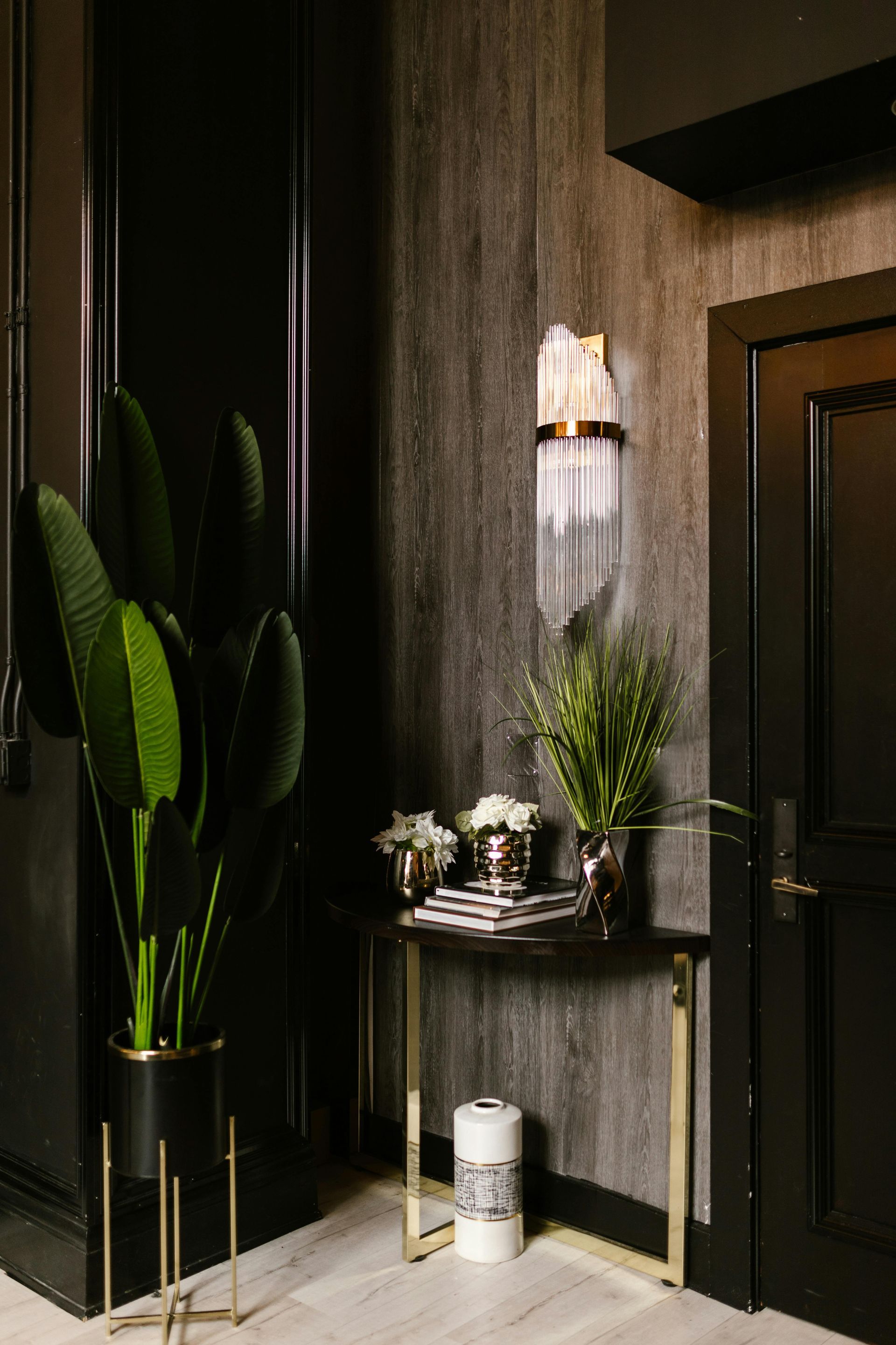 Wall sconce in entry way with plants and modern decor