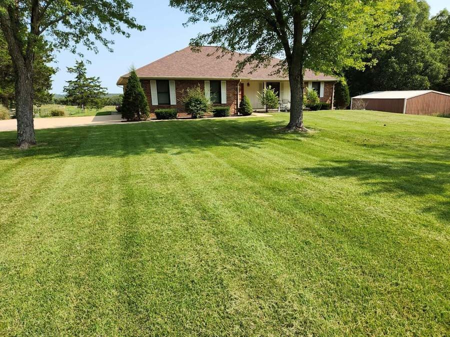 A house with a lush green lawn in front of it.