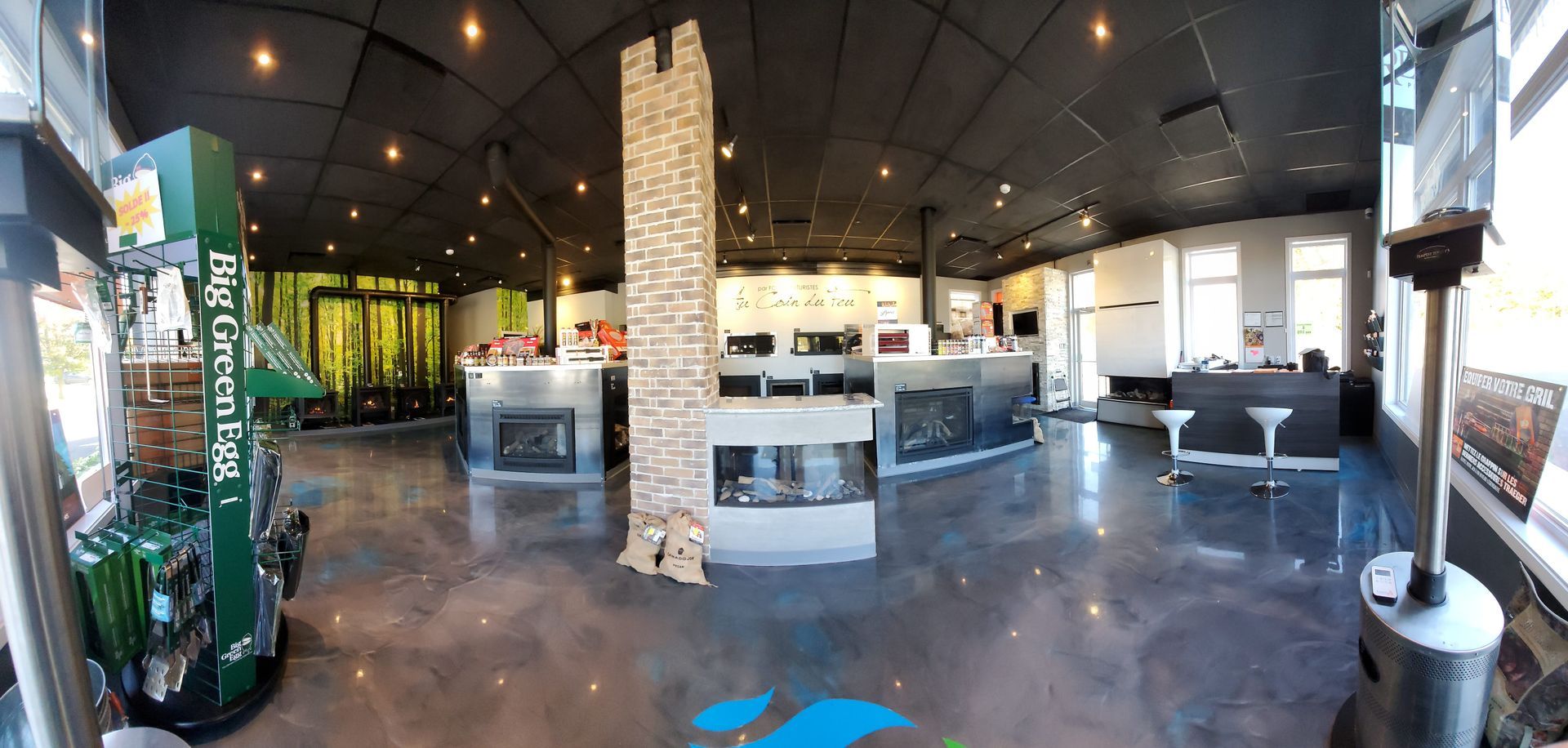 Intérieur d'une salle d'exposition avec cheminées exposées et un pilier central en pierre.