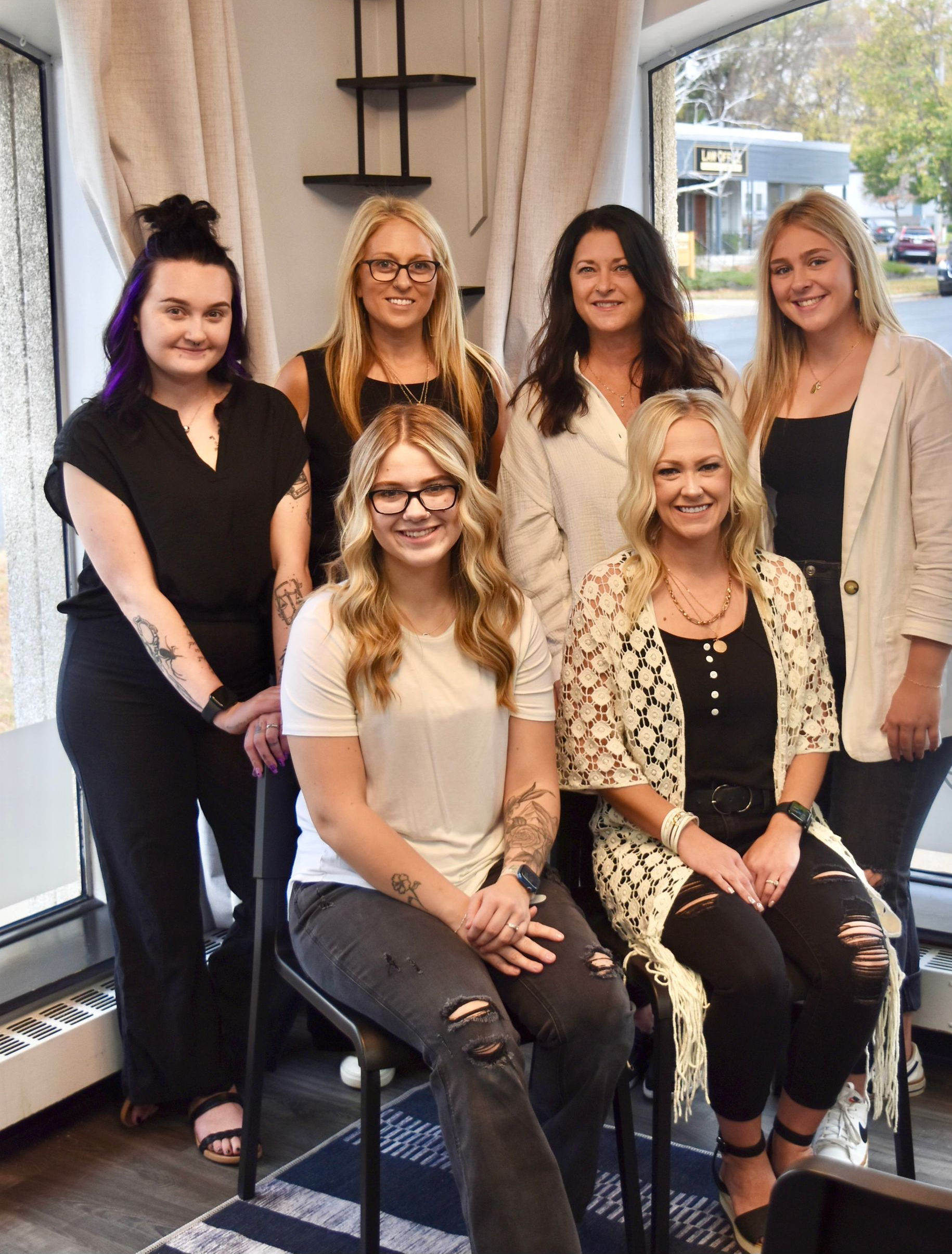 The Professionals from Family Hair salon are smiling for the camera inside.
