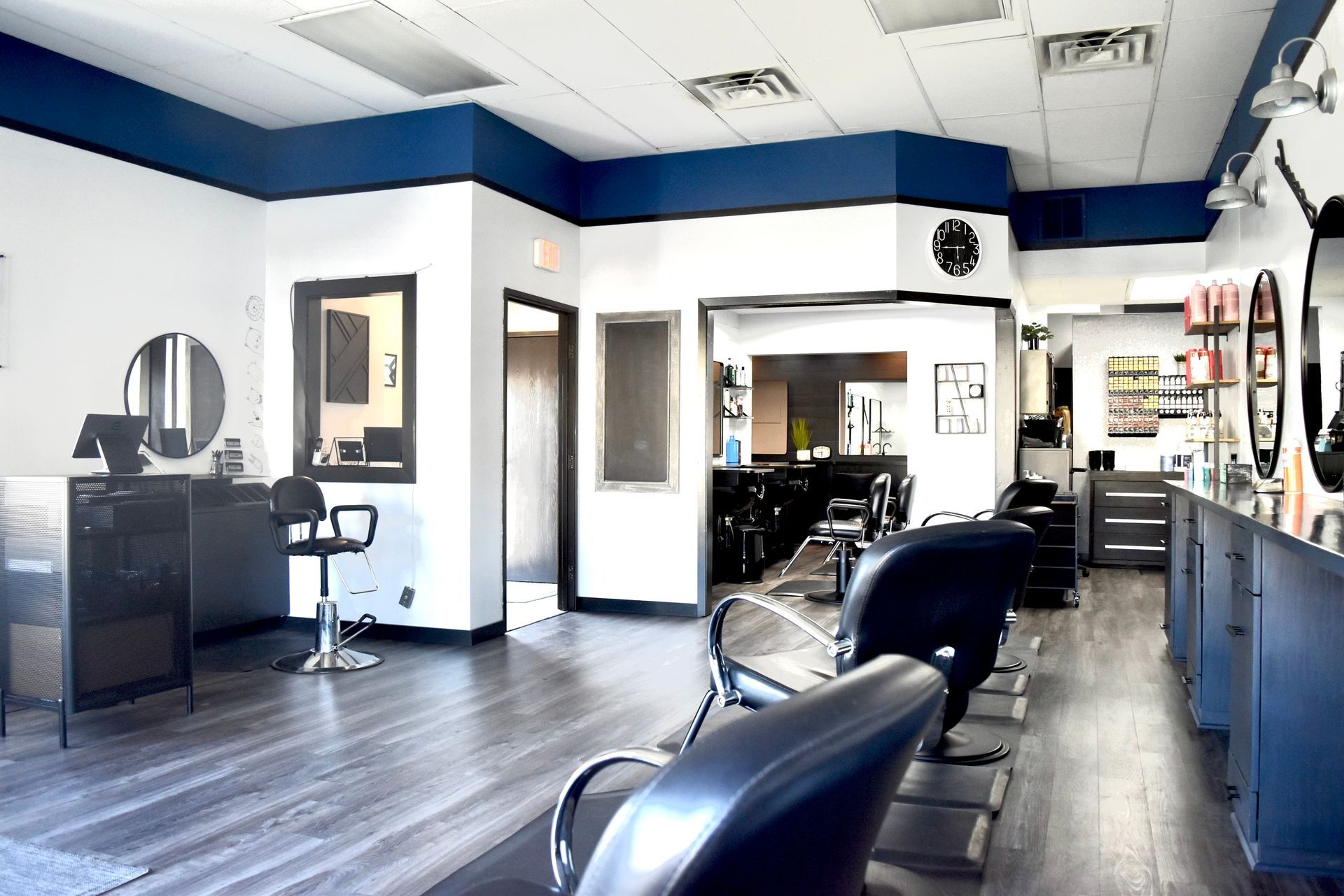 A hair salon with blue and white walls and chairs