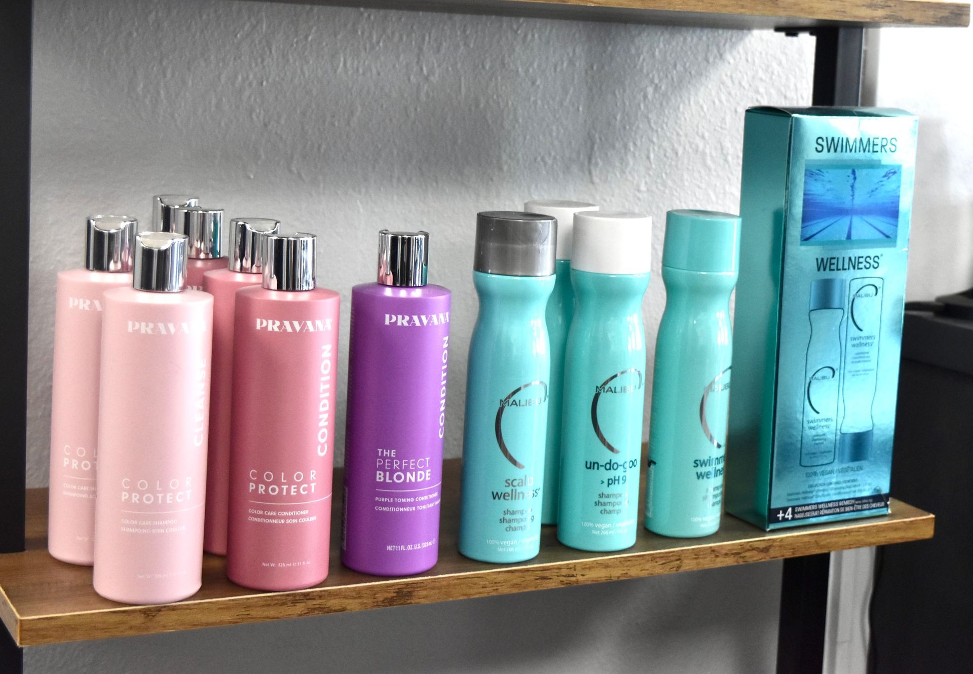 A shelf filled with bottles of shampoo and conditioner