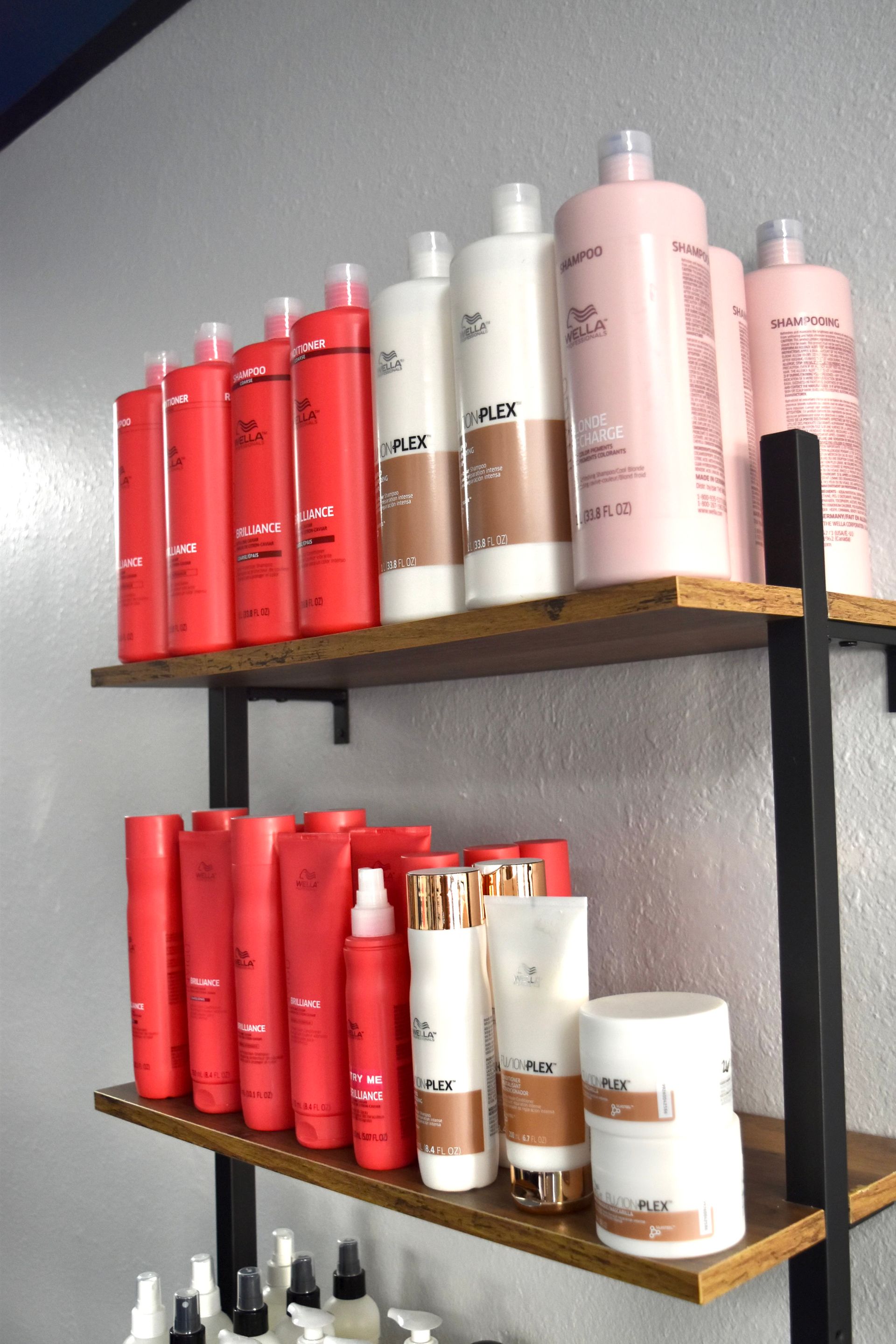 A shelf full of hair products including wella