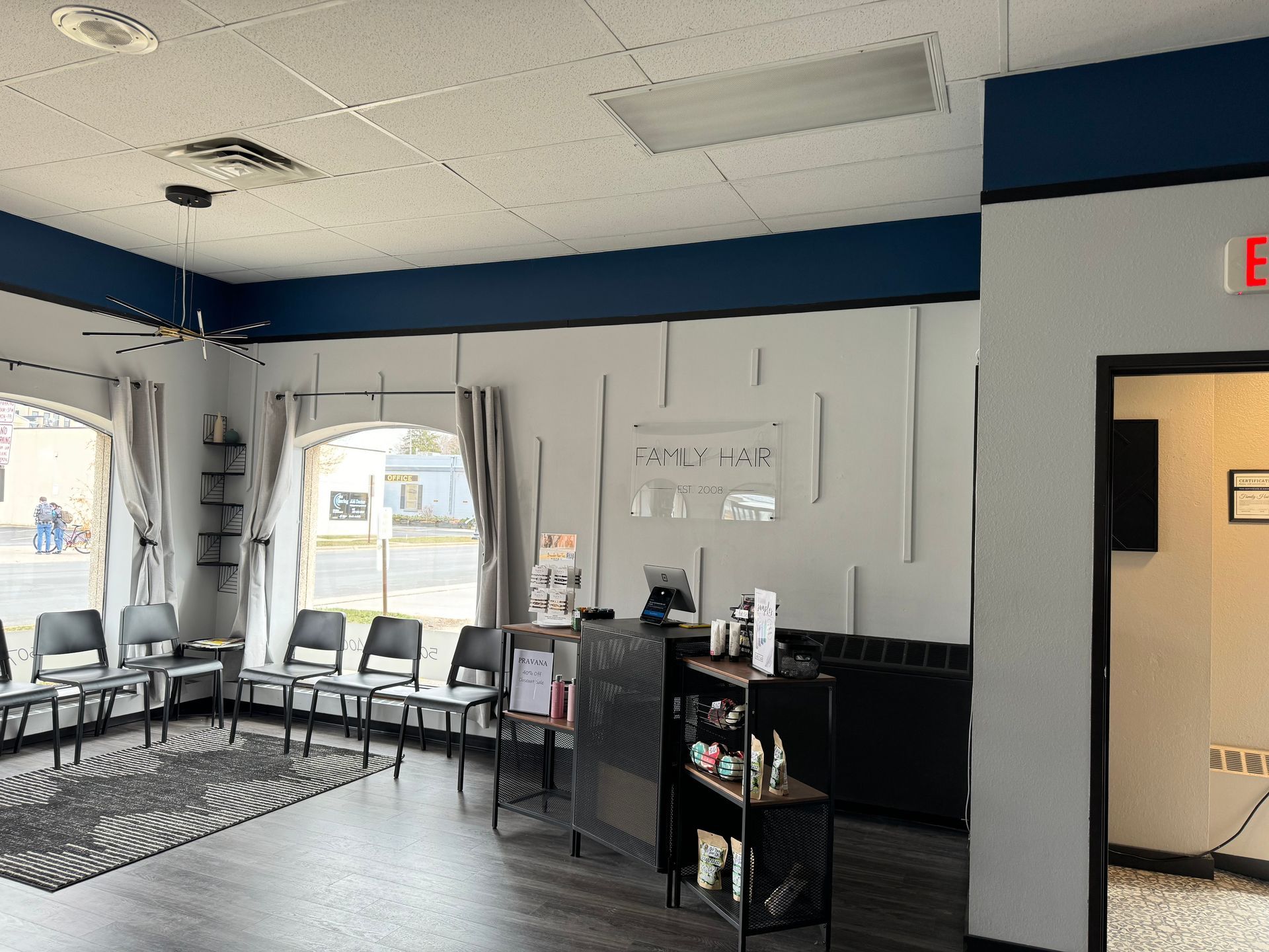 A waiting room with chairs, a reception desk, and a small display. Blue and white decor.
