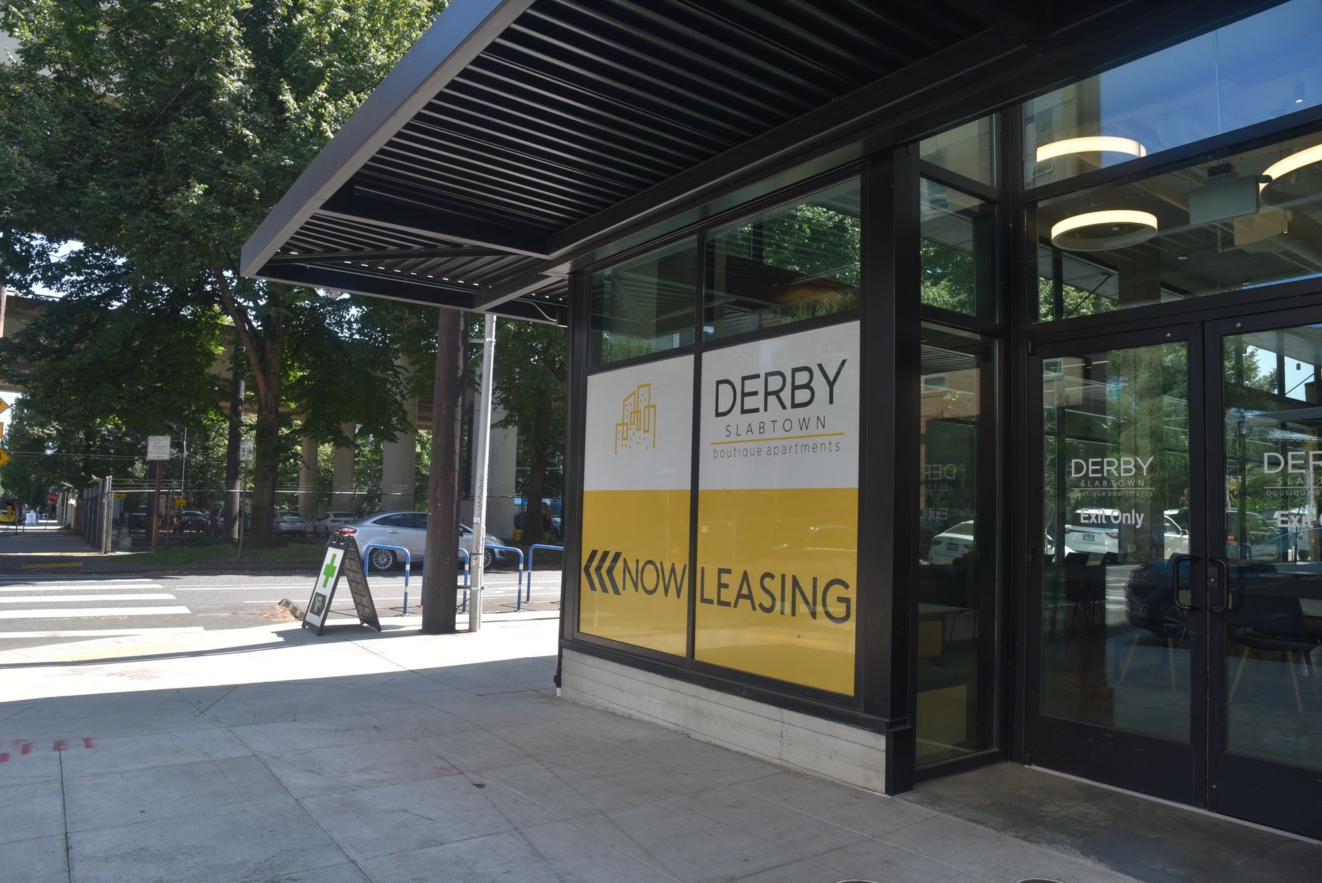 photo showing the building entrance with a now leasing sign