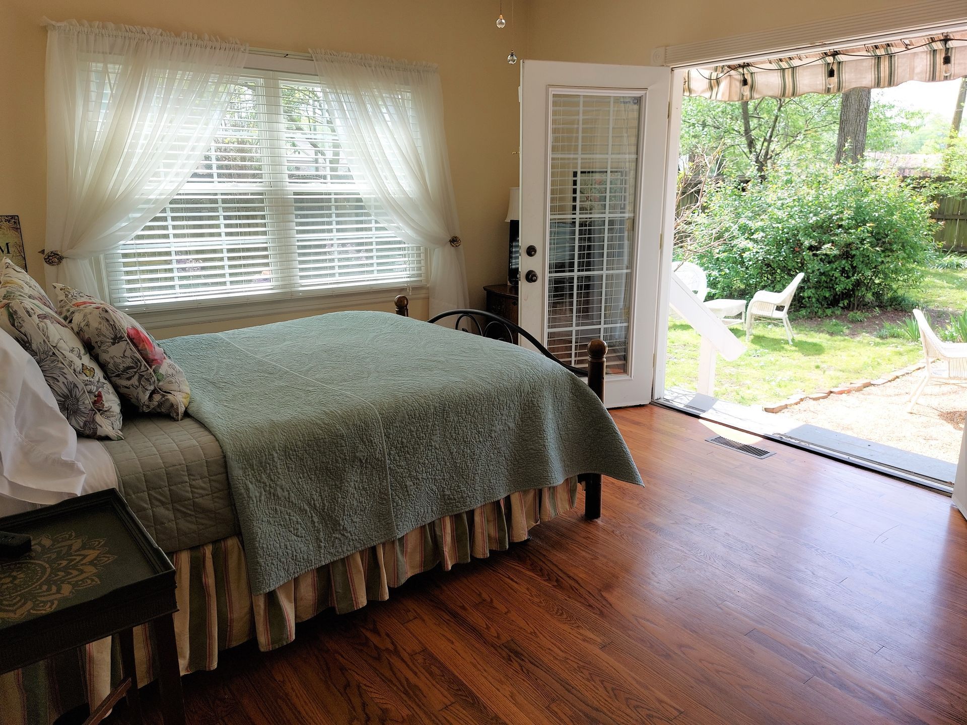 A bedroom with a bed and a sliding glass door leading to a patio.