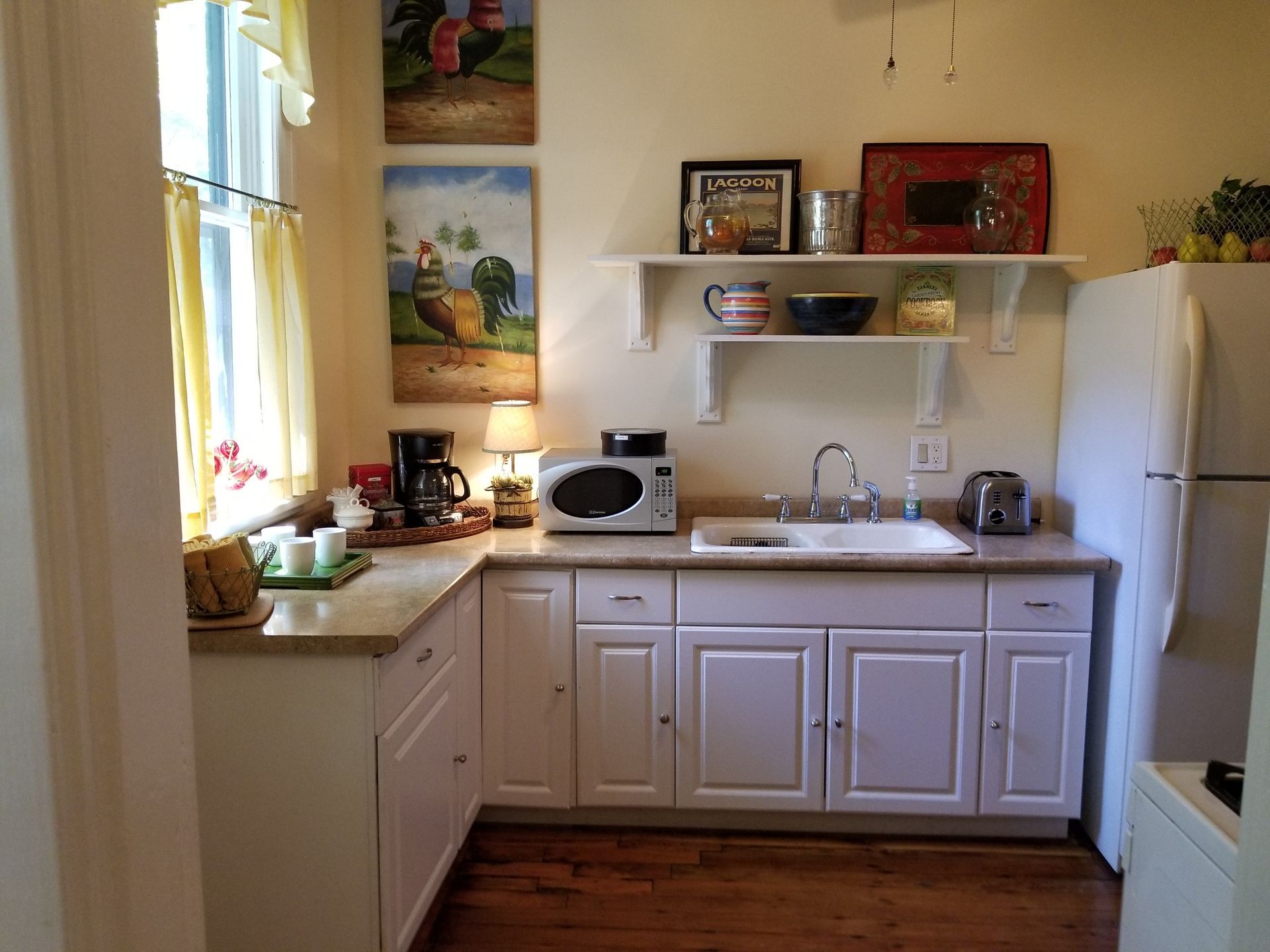 A kitchen with white cabinets and a white refrigerator
