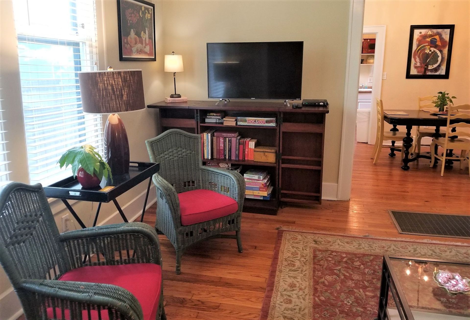 A living room with wicker chairs and a flat screen tv