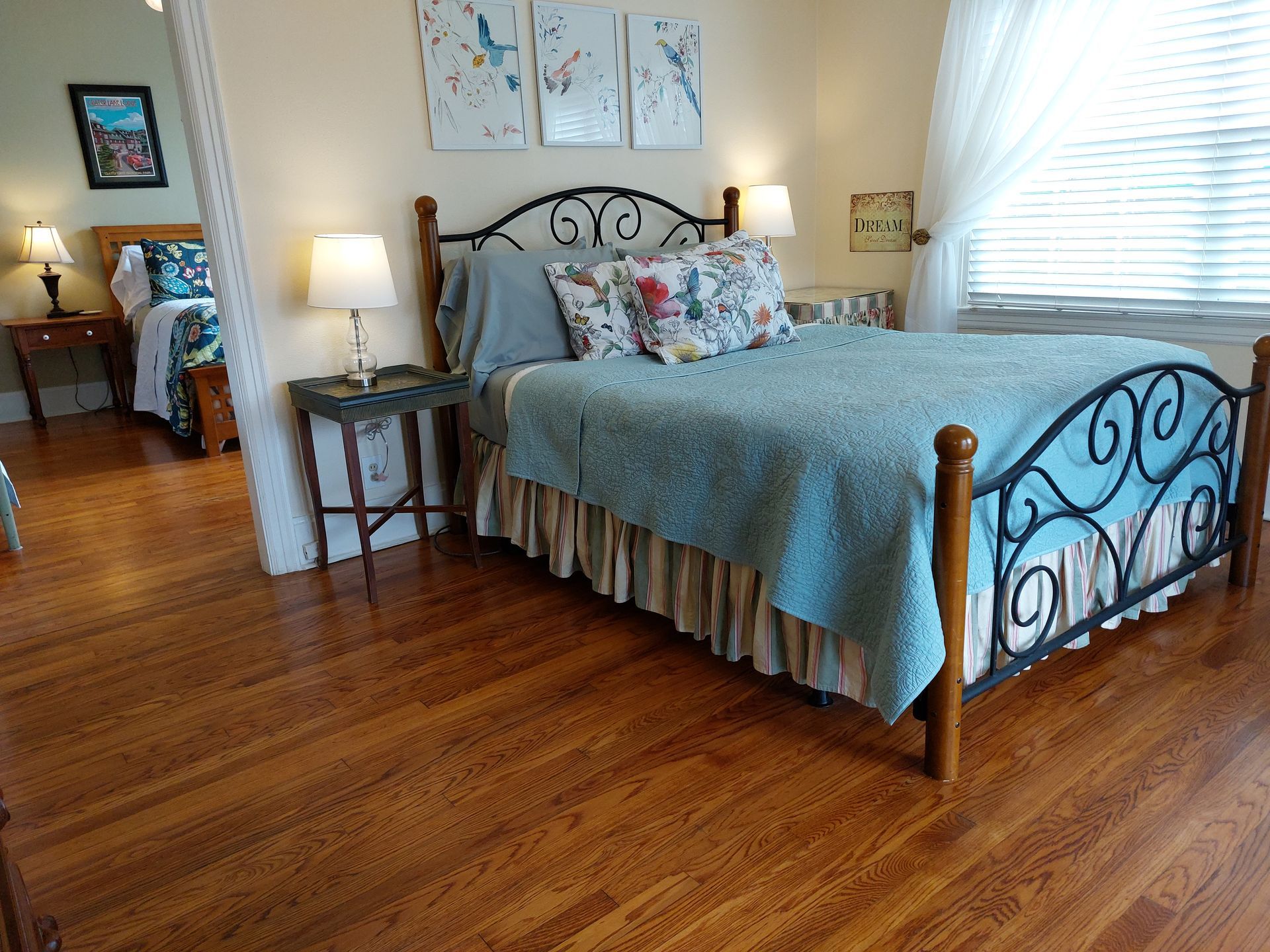 A bedroom with a bed , two nightstands , lamps and a window.