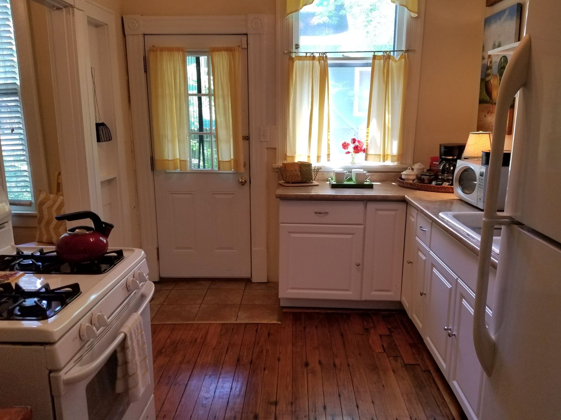 A kitchen with white cabinets a stove and a refrigerator