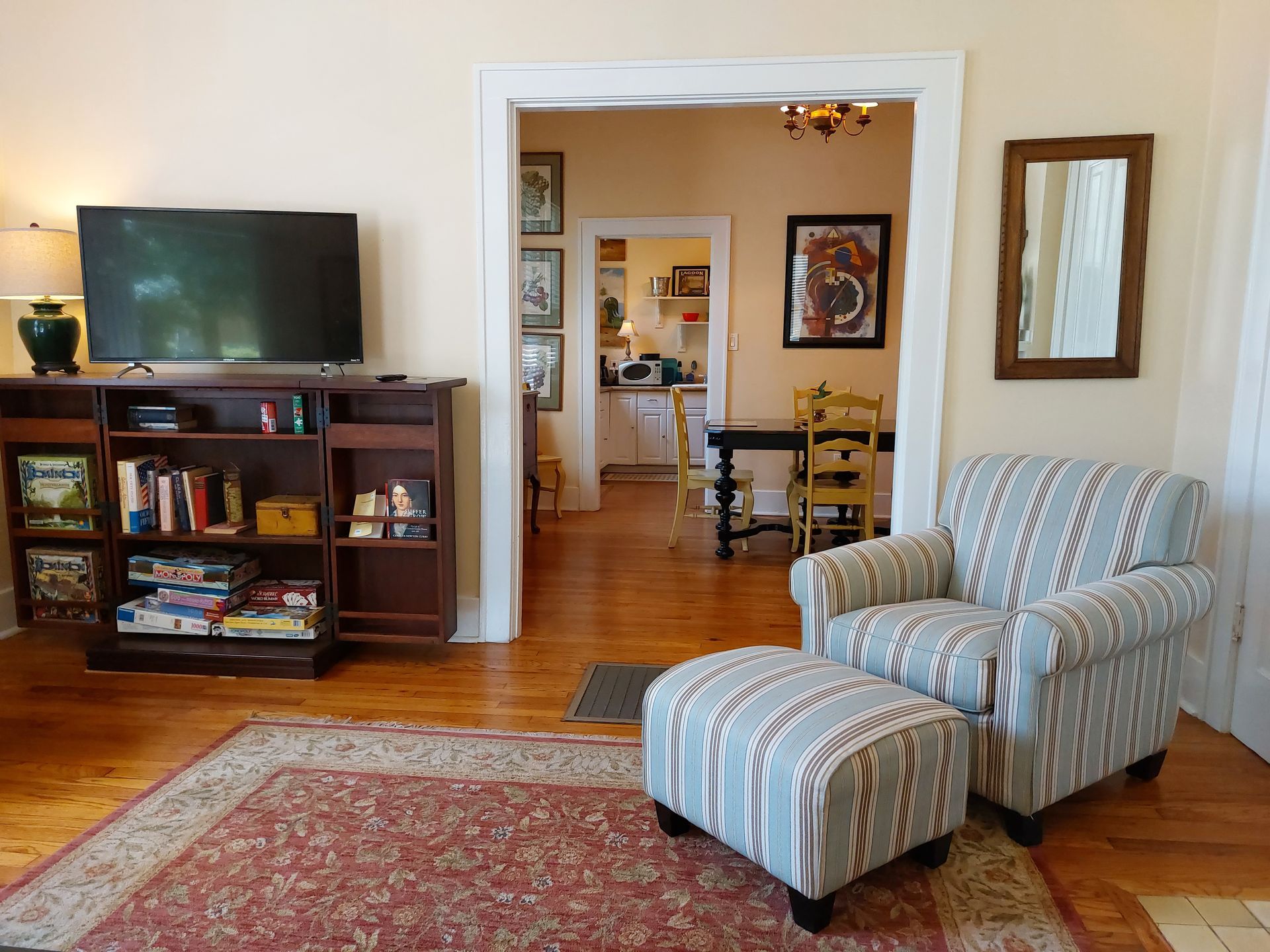 A living room with a chair and ottoman and a flat screen tv