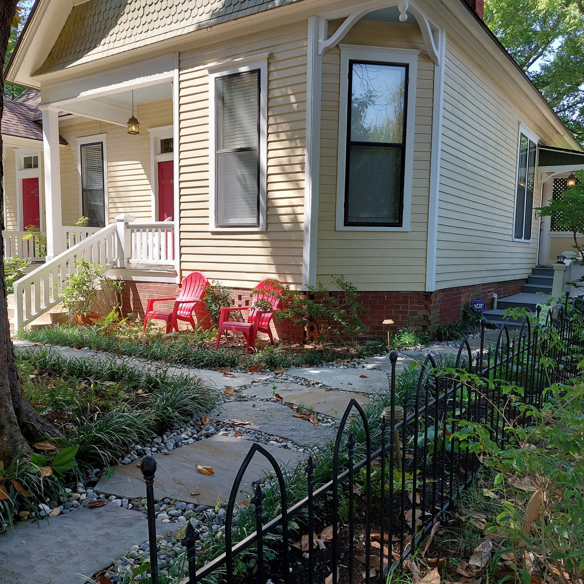A small house with a porch and red chairs