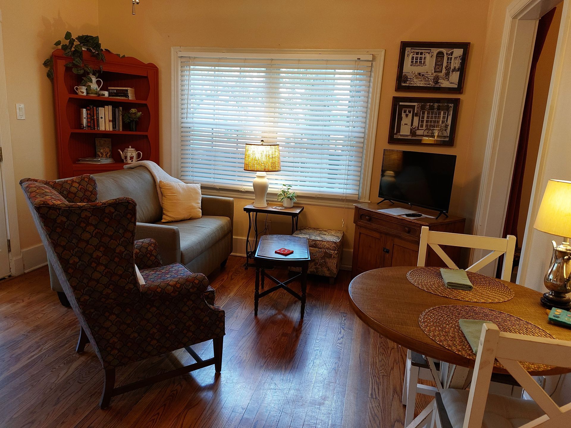 A living room with a couch , chair , table and television