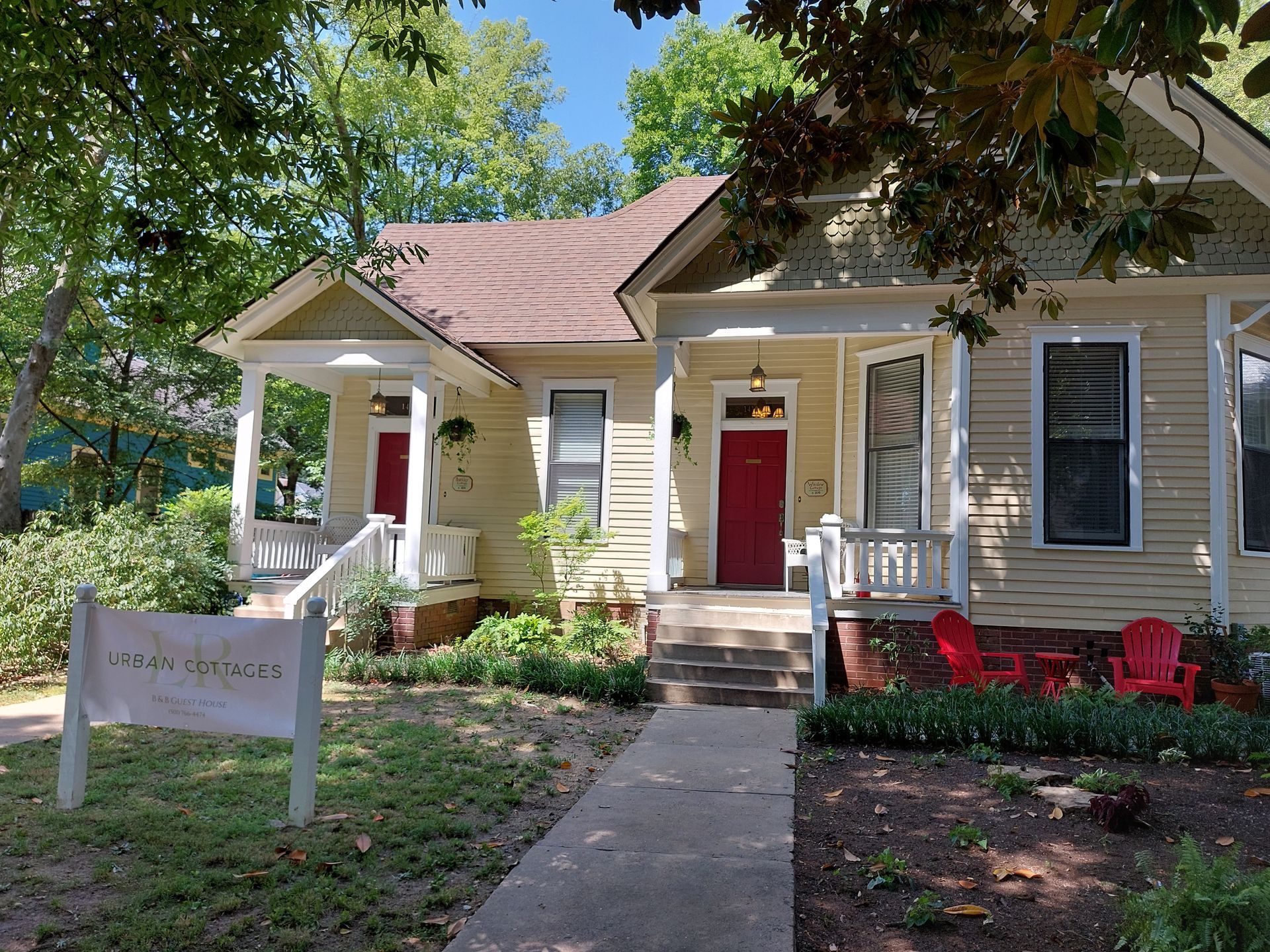 A white house with a red door and a white porch