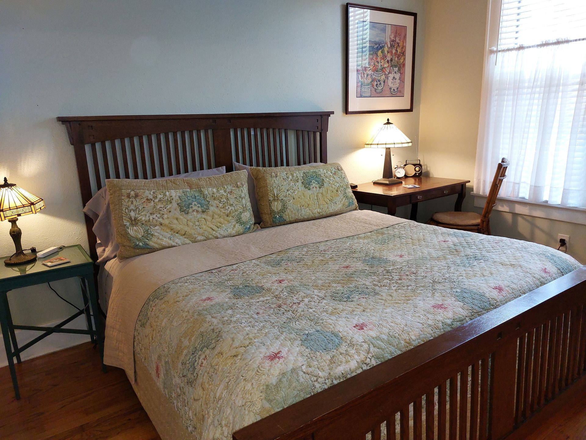 A bedroom with a bed , desk and two lamps