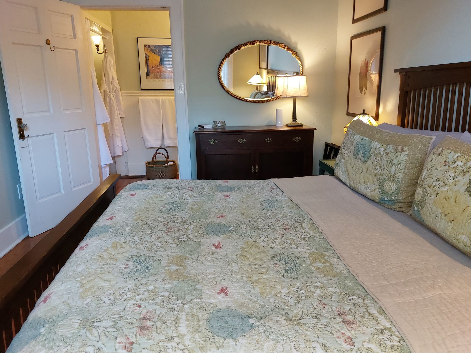 A bedroom with a king size bed and a mirror