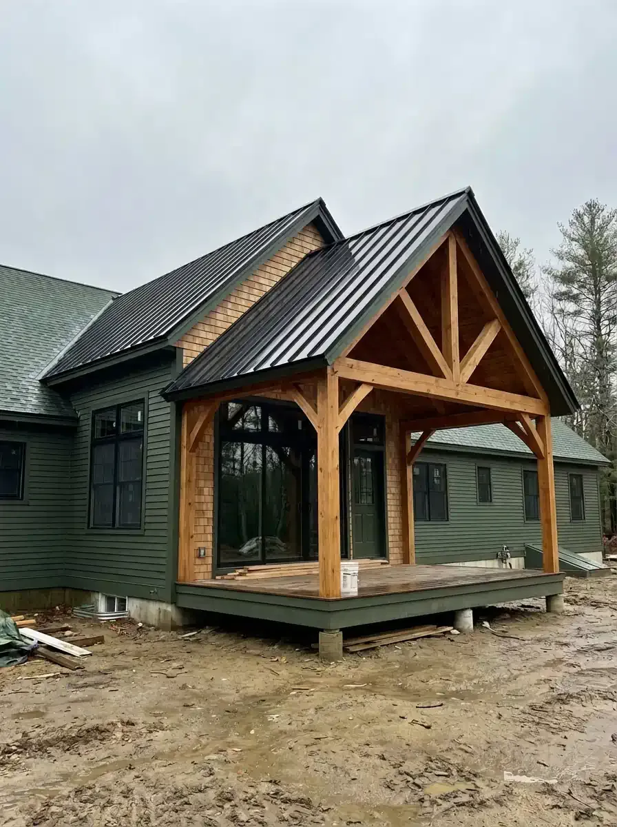 Kitchen with large windows, sunlight, grey cabinets, wooden bar stools, and pendant lights.