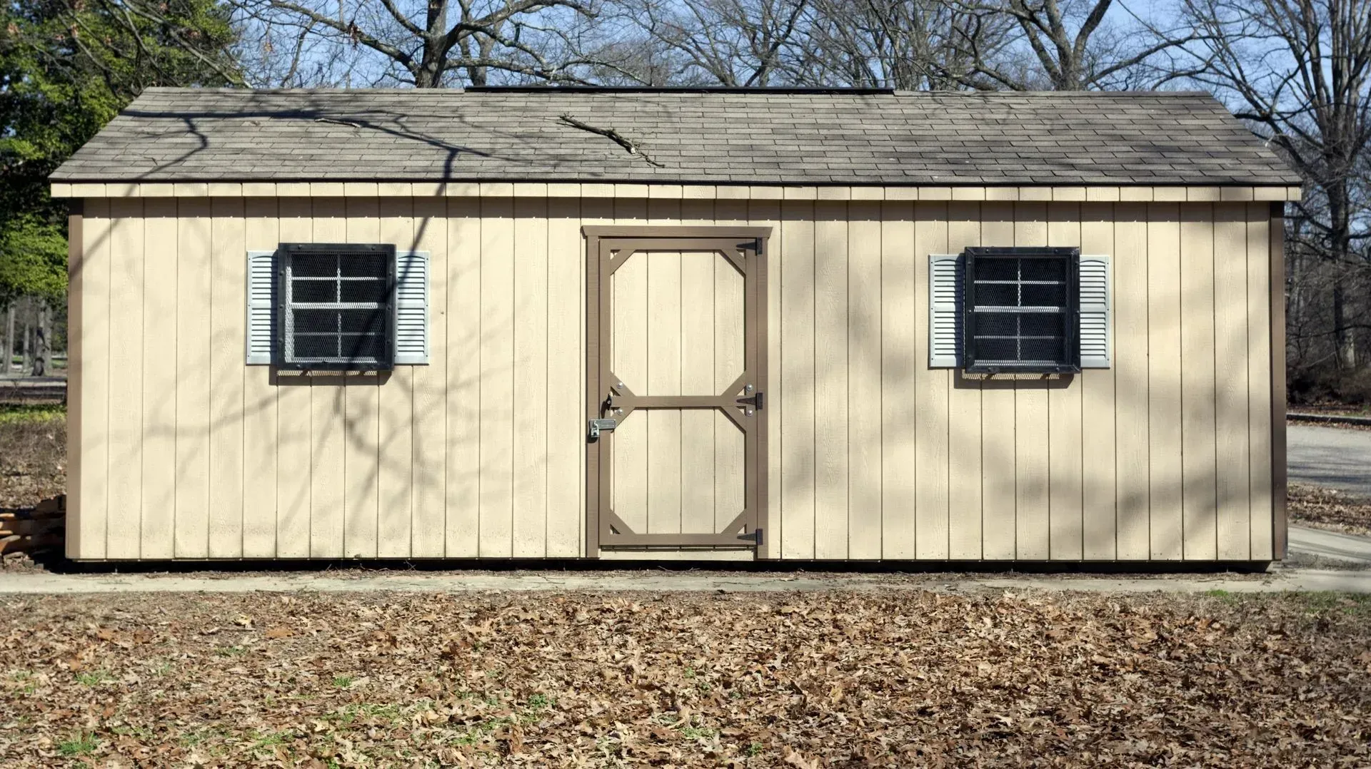 Interior view of a cabin with wood walls and ceiling, wood-burning stove, and a dark floor.