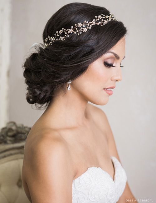 A woman in a wedding dress is wearing a headband in her hair.