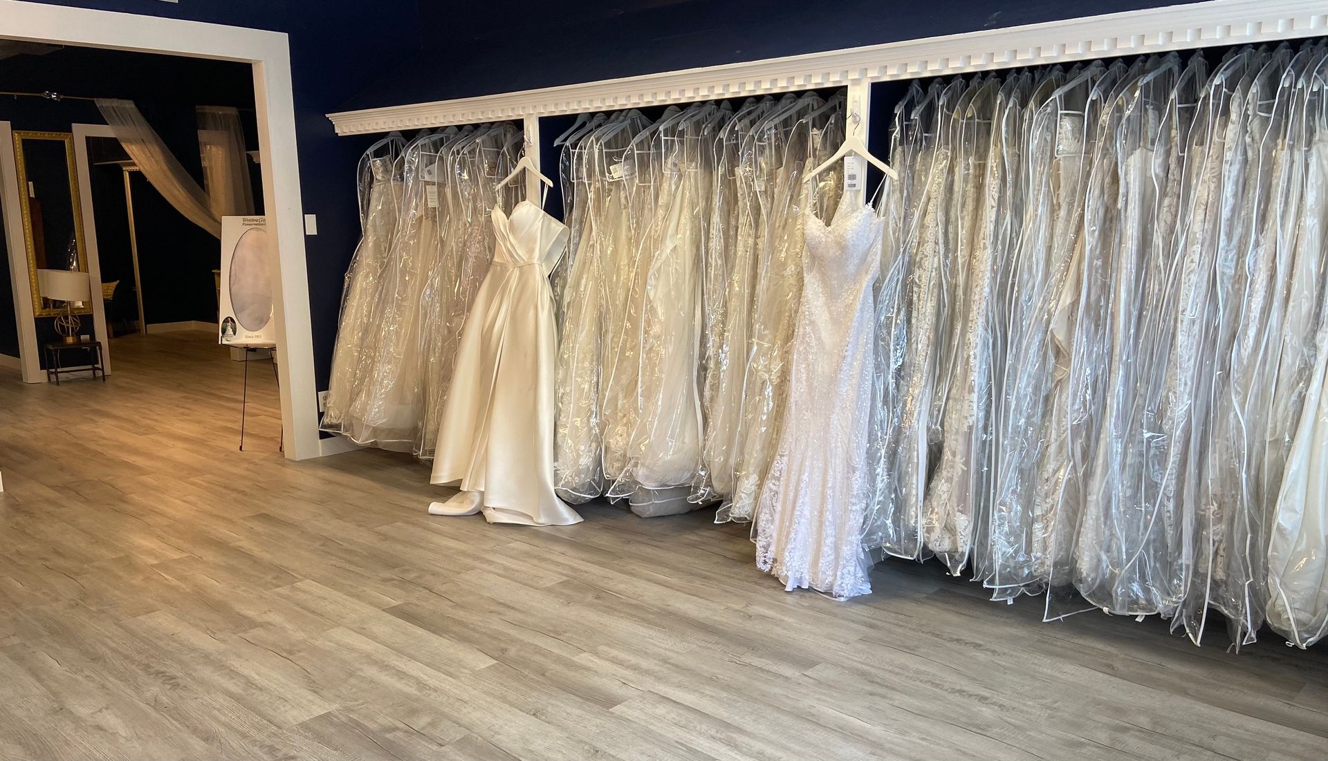 A room filled with lots of wedding dresses and chairs.