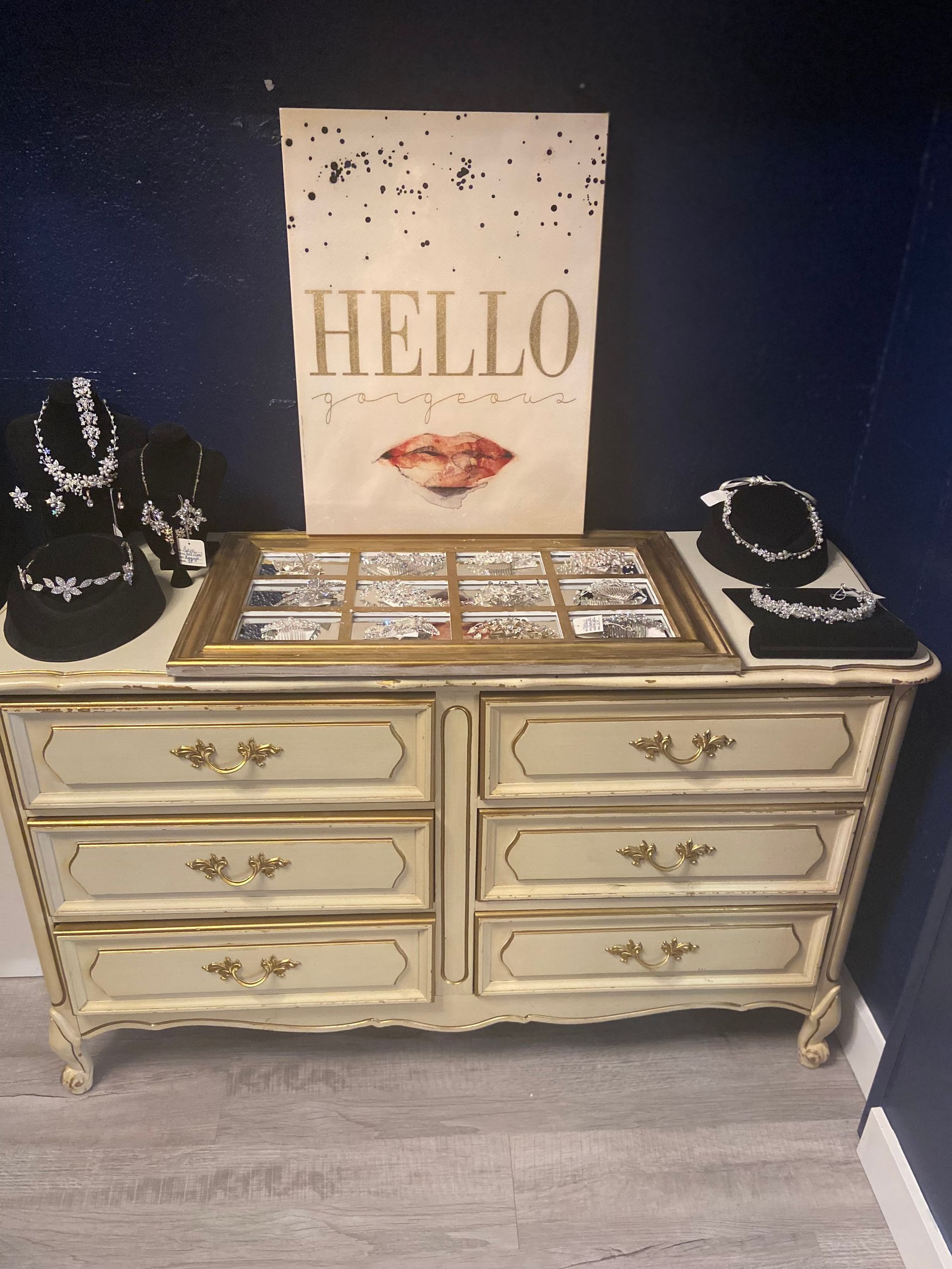 A dresser with a sign that says hello on it and some wedding accessories.