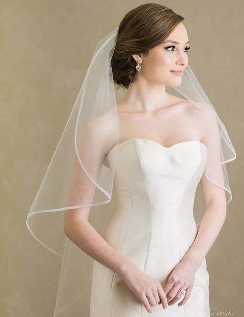 A woman in a wedding dress is wearing a veil.